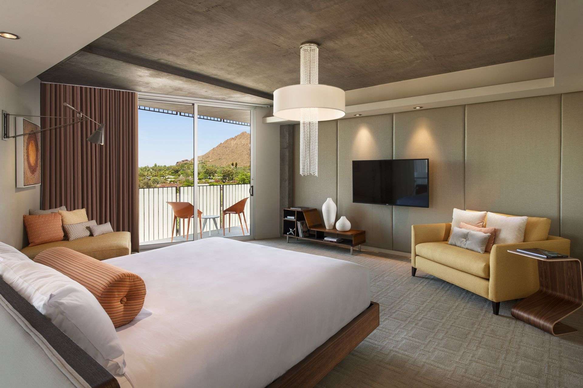 The Presidential Loft bedroom featuring a bed, couch, and TV on the wall.