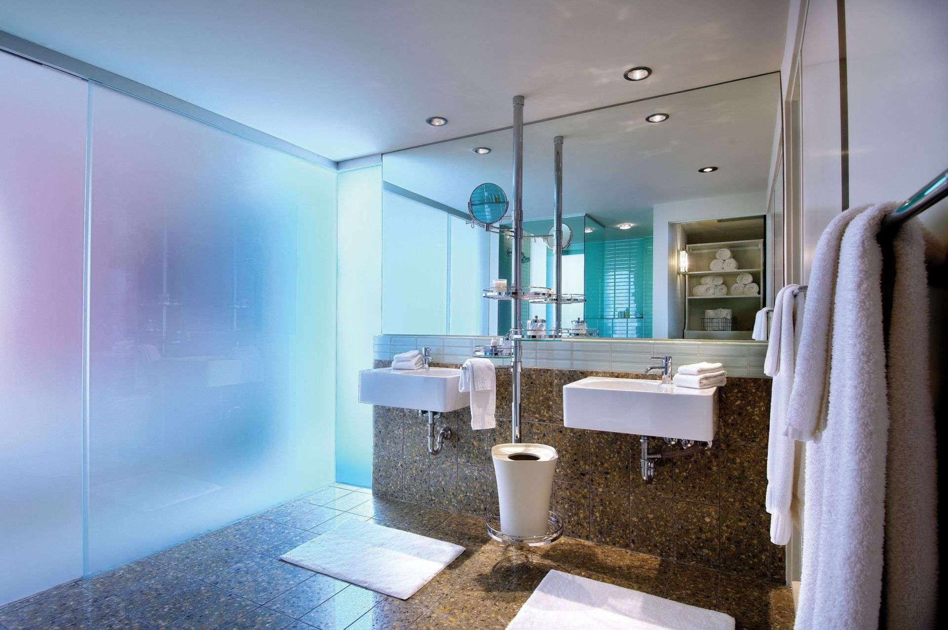 A bathroom featuring two sinks and numerous towels on racks.