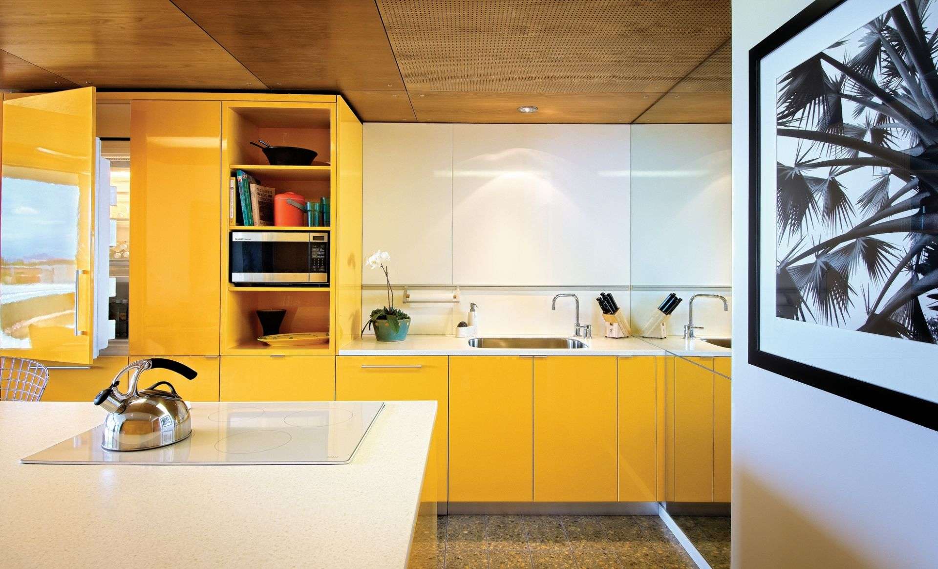 A decorated kitchen with a kettle on the counter.