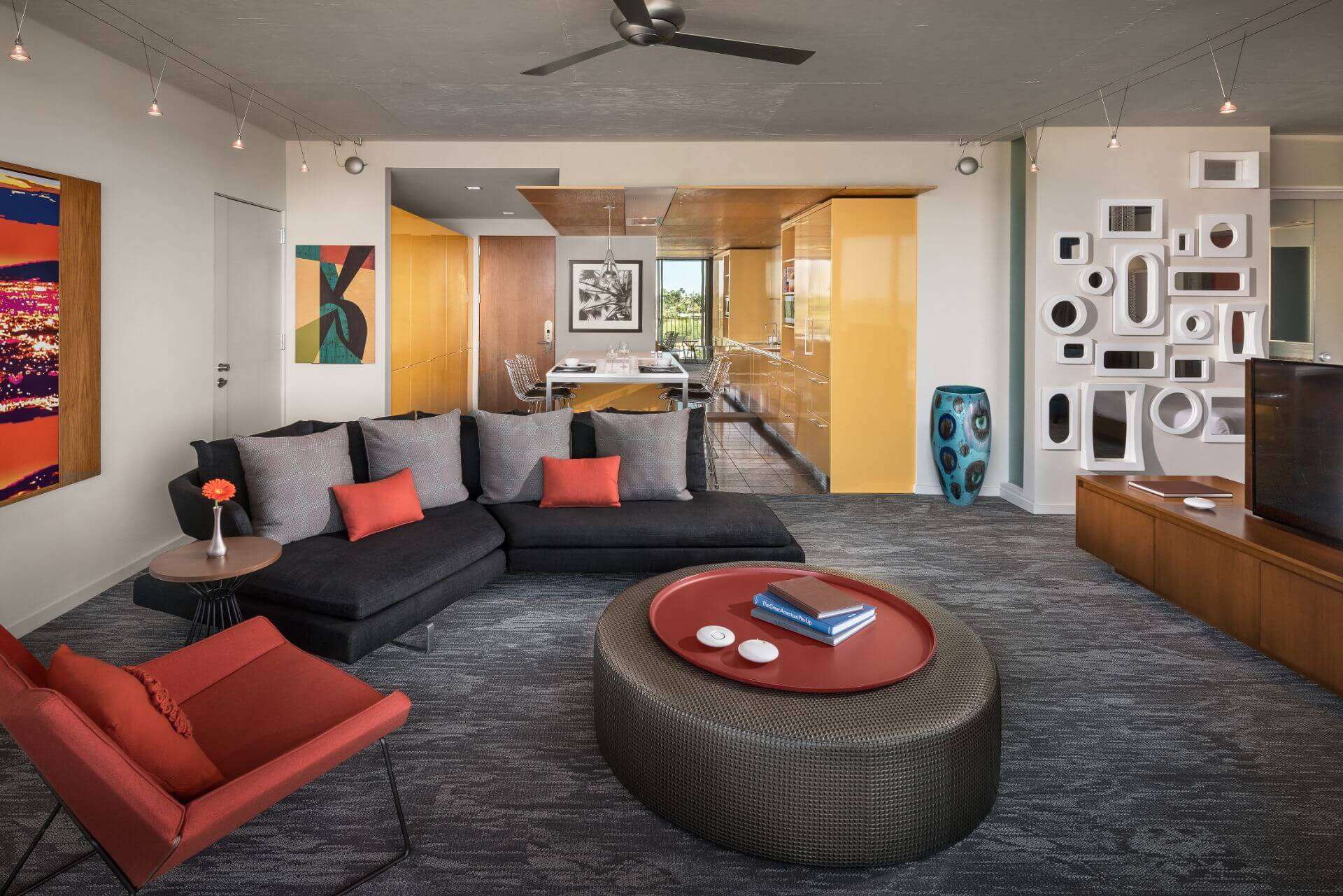A room featuring a couch, circular table and various decorations on the wall.