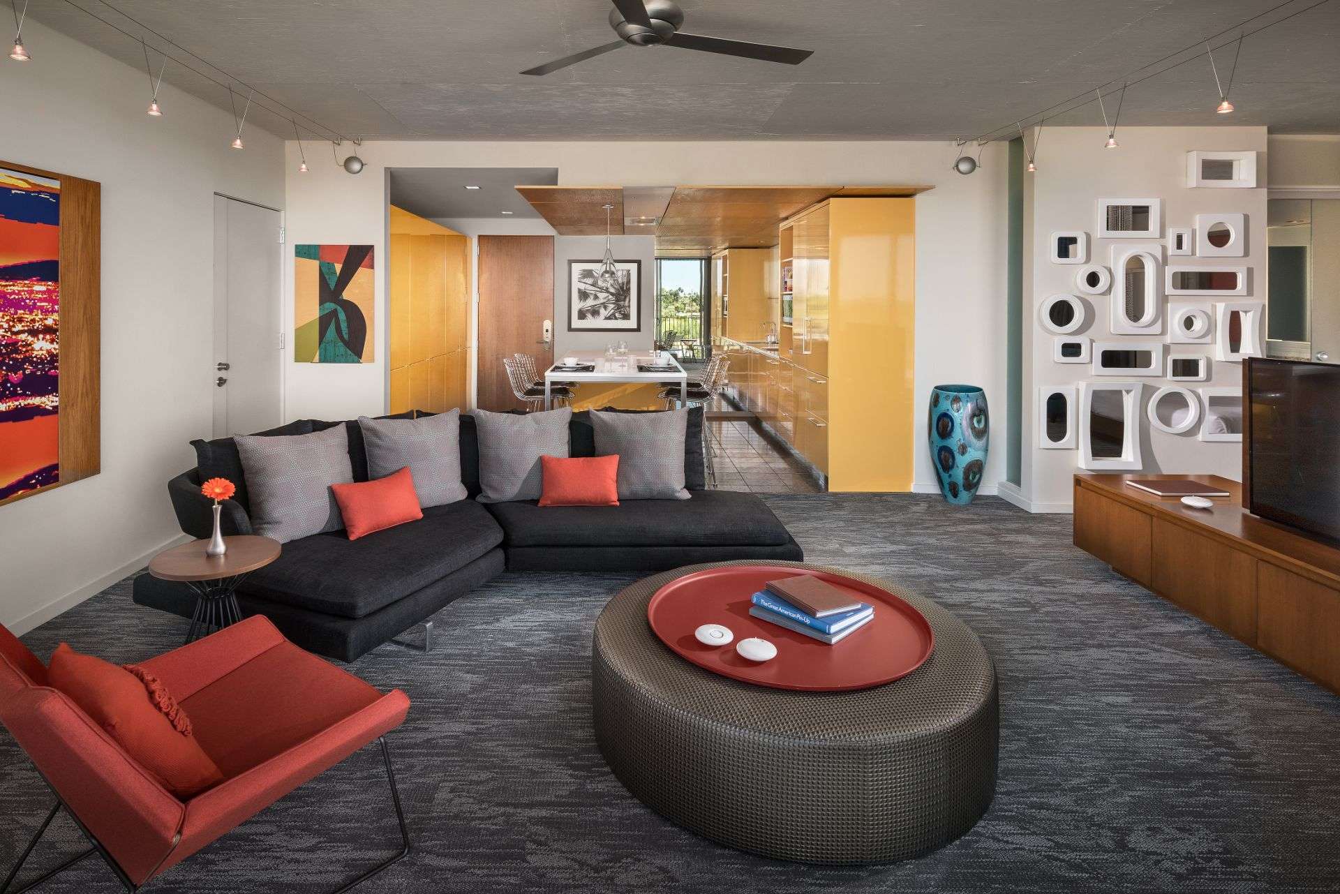 A room featuring a couch, circular table and various decorations on the wall.