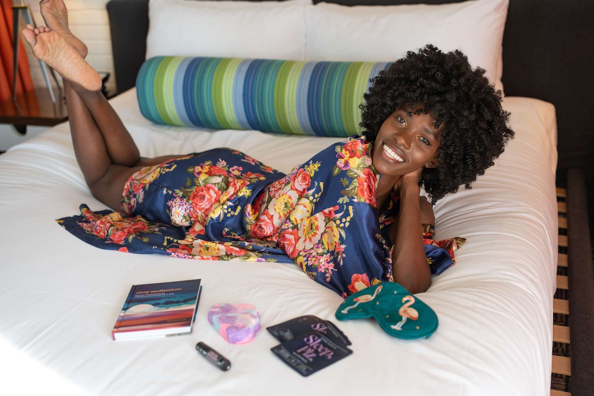 Woman lounging on bed with books.