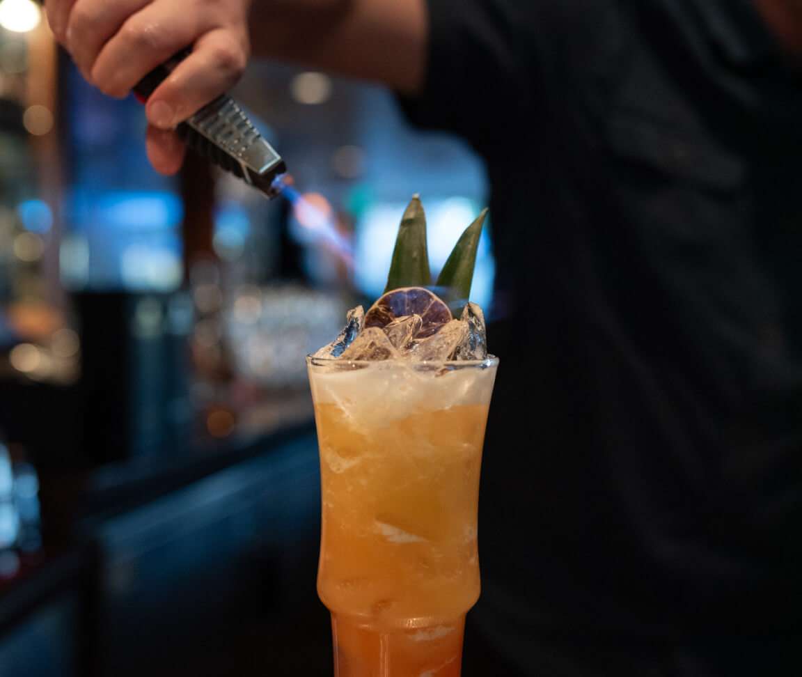 Bartender pouring a drink into glass.
