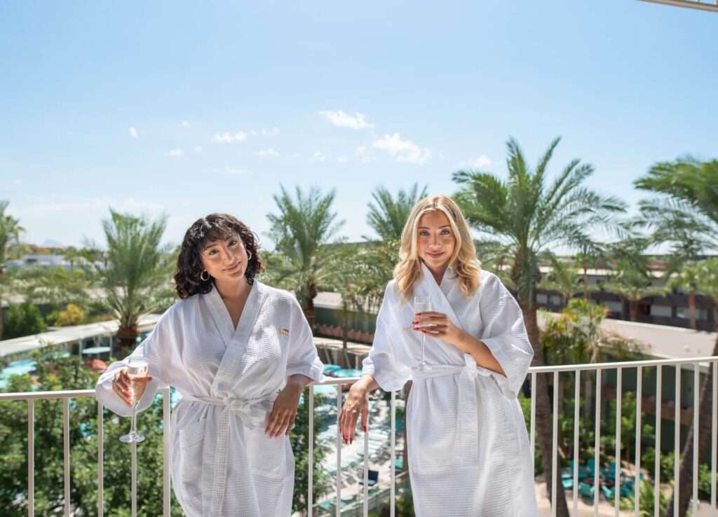Women in robes enjoying pool view.