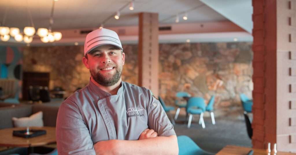 Chef in hat stands proudly
