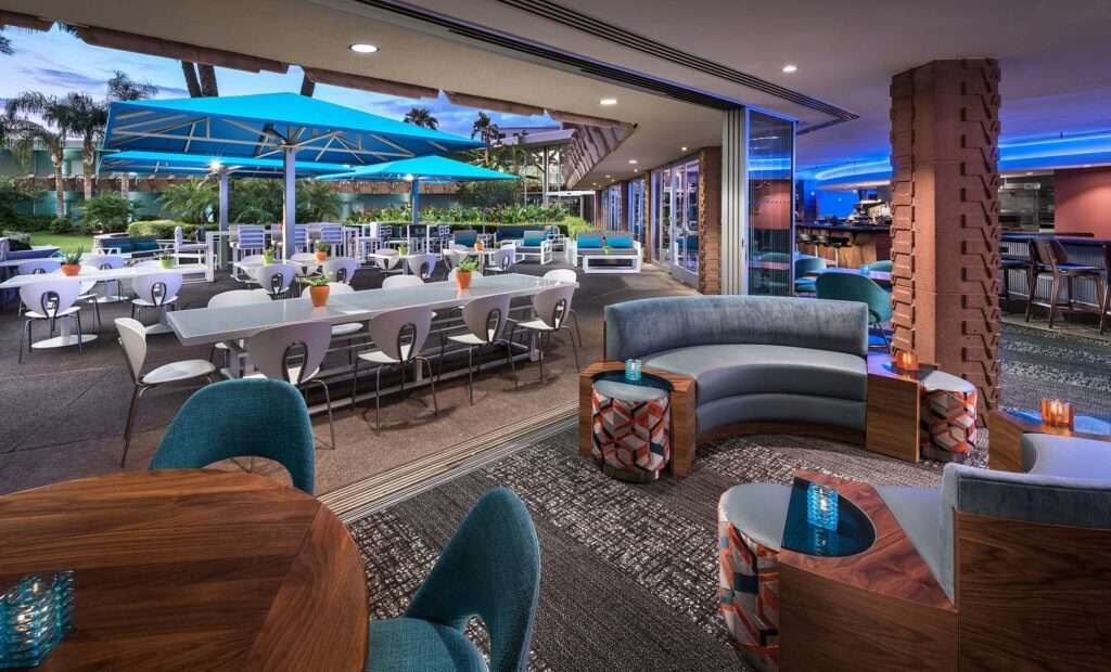 Outside sitting area with chairs and tables as well as an inside lounge.