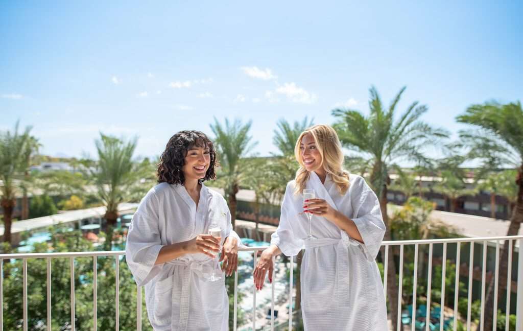 two women in spa robes on a guestroom balcony